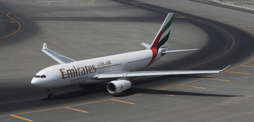 Dubai International Airport terminal with passengers and Emirates aircraft