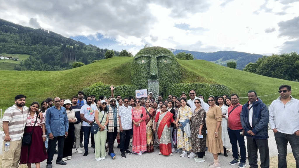 Go Global Vacations Europe tour group at Swarovski Crystal Worlds in Austria, posing in front of the iconic Giant head landmark